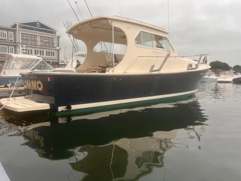 Slide: The Image of 2004 Mainship 30 Pilot II Express Cruiser docked in a marina. - 2