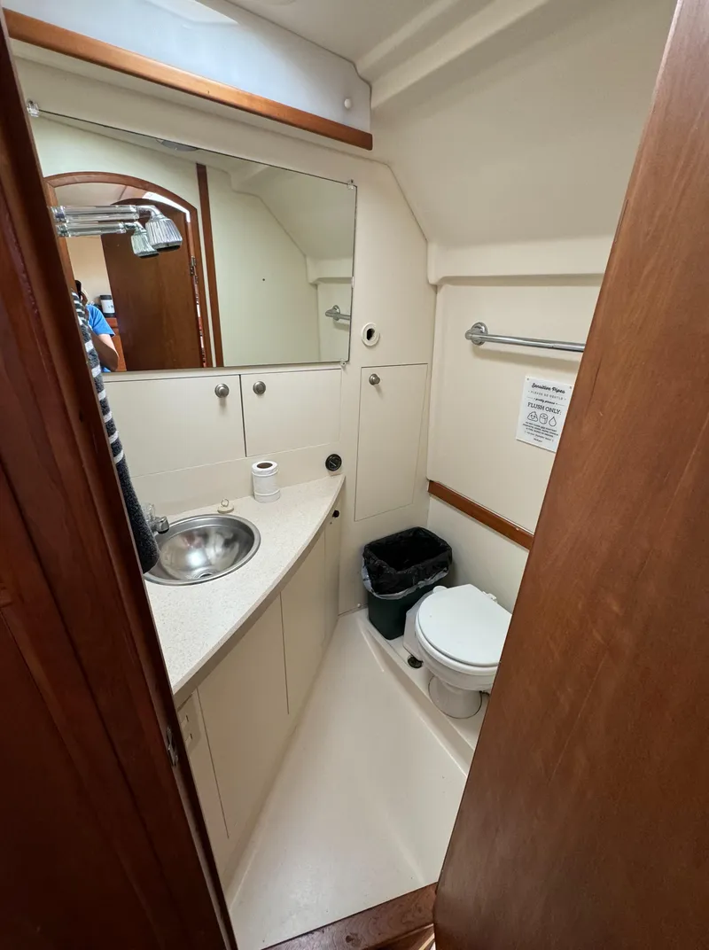 Slide: The Image of 2004 Mainship 30 Pilot II Express Cruiser bathroom with sink, toilet, and mirror. - 23