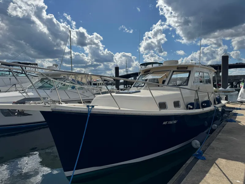 Slide: The Image of 2004 Mainship 30 Pilot II Express Cruiser docked under a partly cloudy sky. - 3