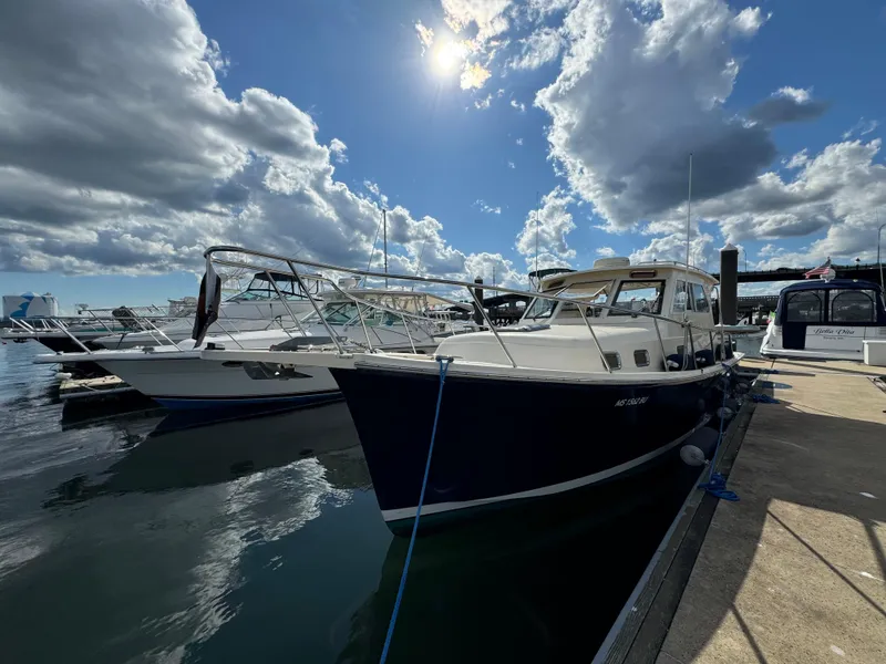 Slide: The Image of 2004 Mainship 30 Pilot II Express Cruiser docked under a partly cloudy sky. - 4