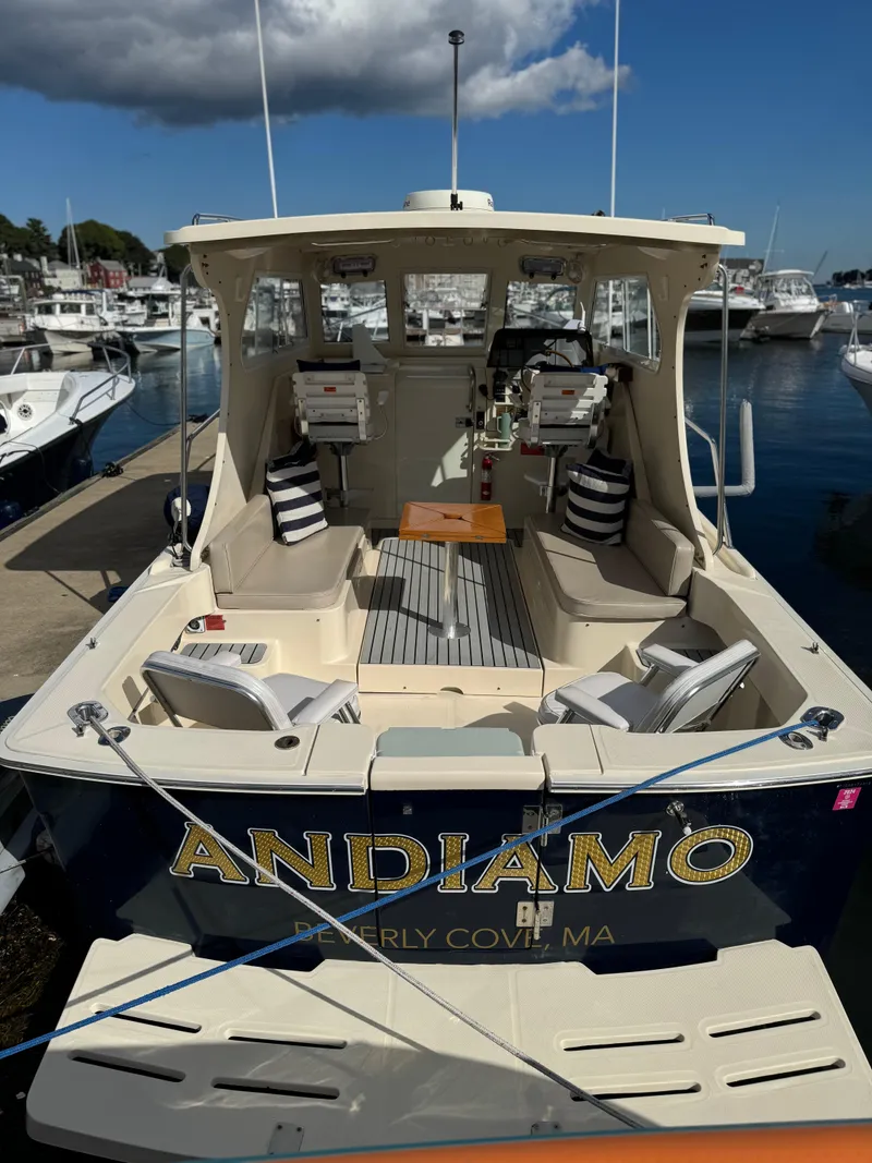 Slide: The Image of 2004 Mainship 30 Pilot II Express Cruiser docked, featuring spacious seating and elegant design. - 5