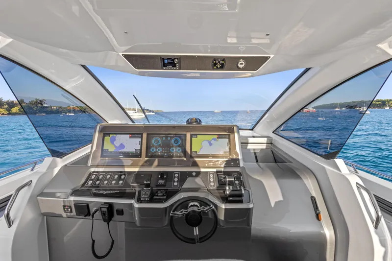 Slide: The Image of 2025 Canados 571 yacht cockpit with advanced navigation systems, overlooking serene blue waters. - 10