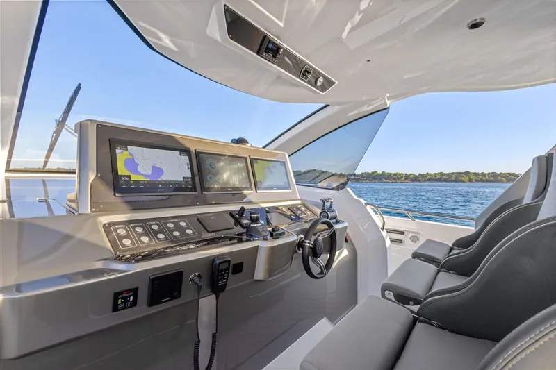 Slide: The Image of Cockpit of 2025 Canados 571 yacht with modern navigation systems and ocean view. - 9