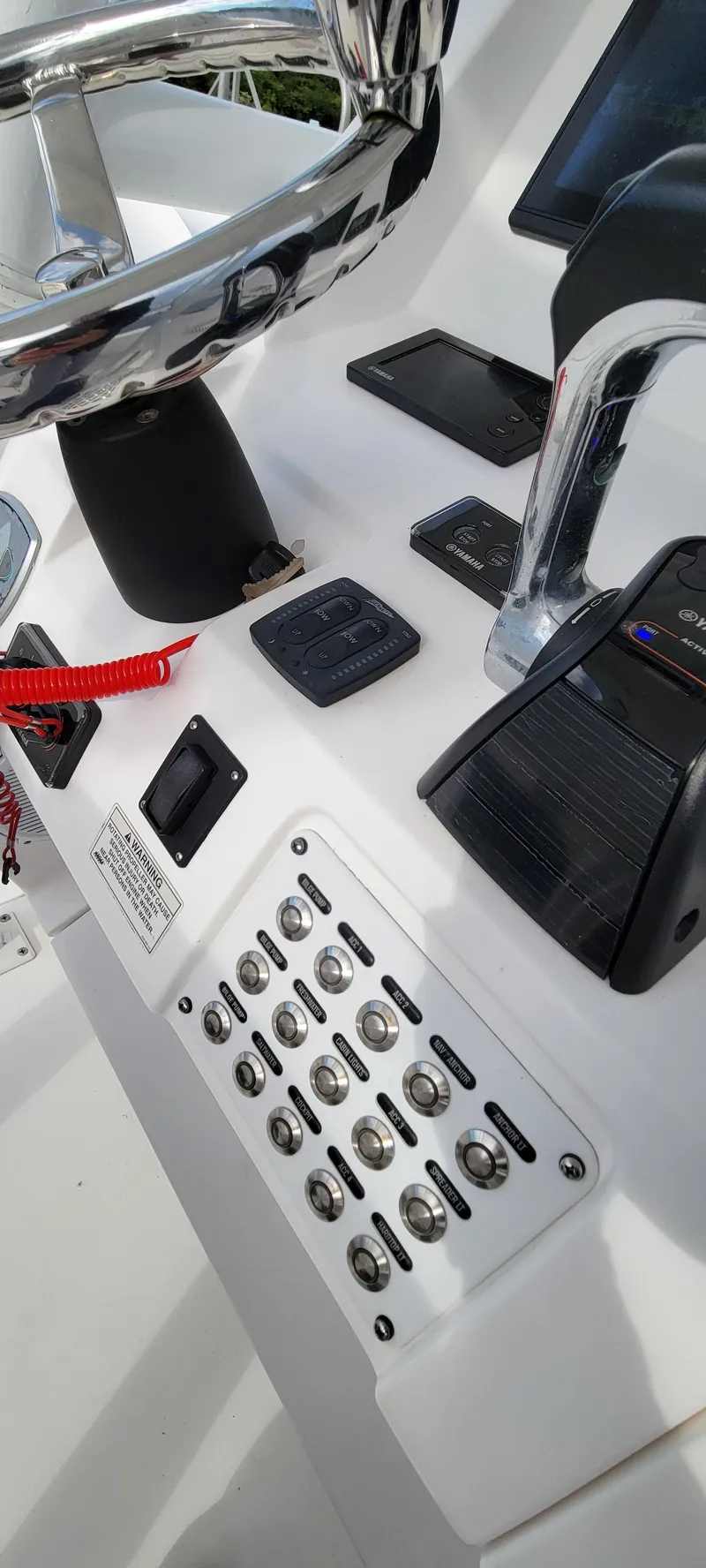 Slide: The Image of Control panel of a 2016 Intrepid 327 Cuddy boat with switches and steering wheel. - 14