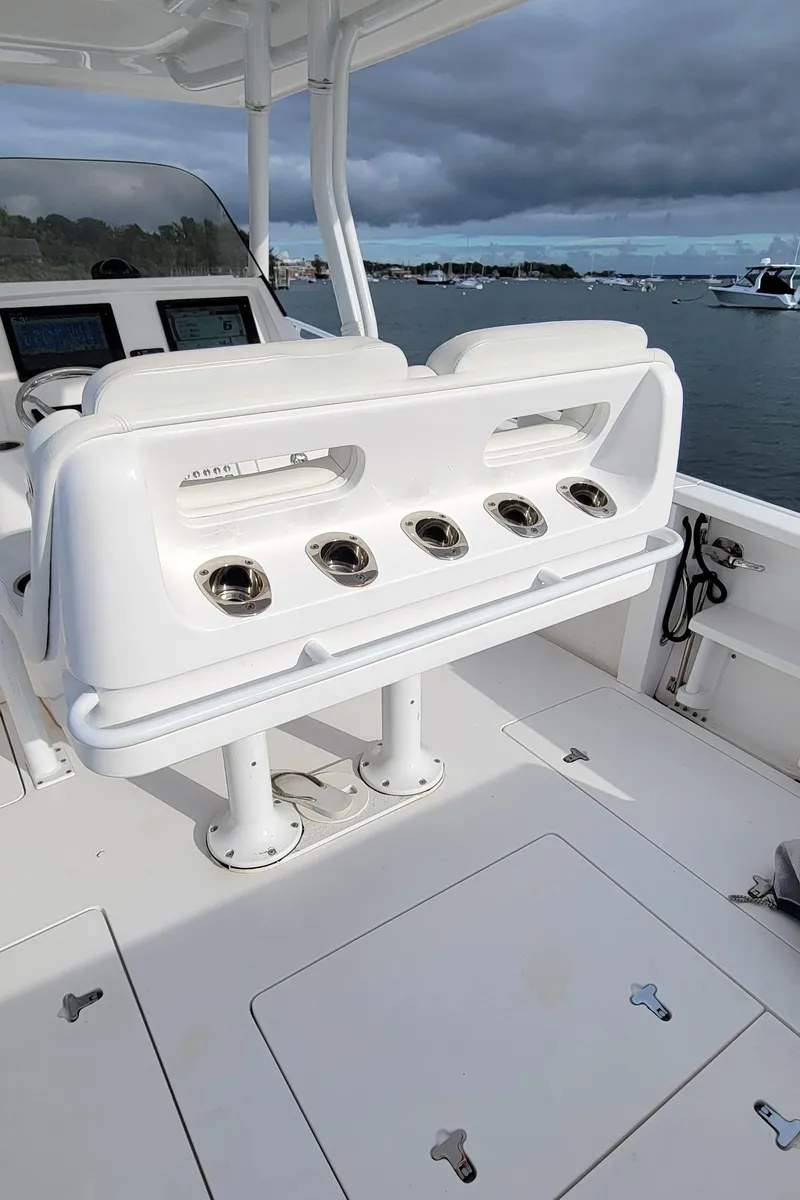Slide: The Image of 2016 Intrepid 327 Cuddy boat interior with rod holders, ocean view. - 17