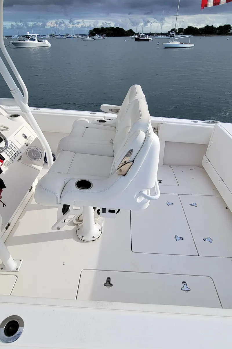 Slide: The Image of 2016 Intrepid 327 Cuddy boat interior with white seating and ocean view. - 19