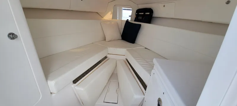 Slide: The Image of 2016 Intrepid 327 Cuddy cabin interior with white seating and cushions. - 21