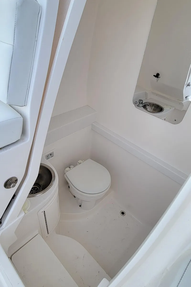 Slide: The Image of 2016 Intrepid 327 Cuddy boat bathroom with toilet and sink. - 22