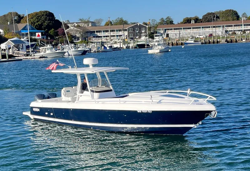 Slide: The Image of 2016 Intrepid 327 Cuddy boat cruising in a scenic marina. - 26