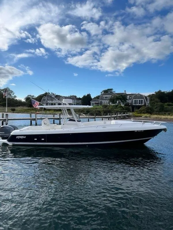 Slide: The Image of 2016 Intrepid 327 Cuddy boat on calm water with scenic background. - 5