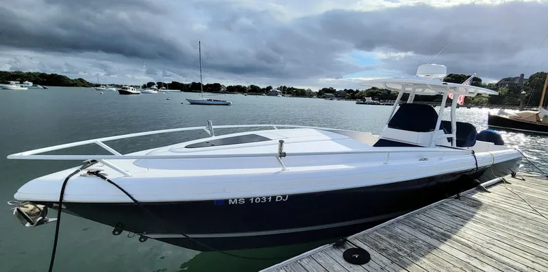 Slide: The Image of 2016 Intrepid 327 Cuddy boat docked on a calm lake under cloudy skies. - 7