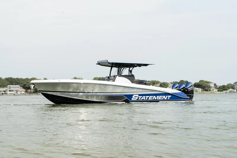 Slide: The Image of 2023 Statement 380 Open boat on trailer, surrounded by trees and other boats. - 1