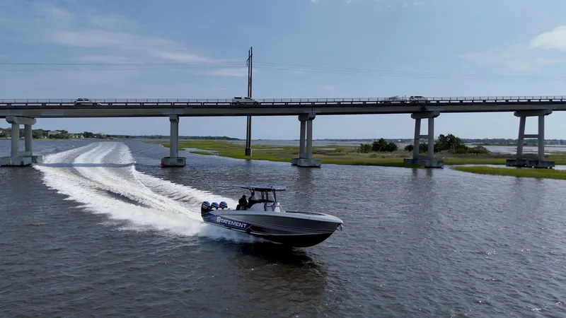 Slide: The Image of 2023 Statement 380 Open boat cruising under a bridge on a sunny day. - 29