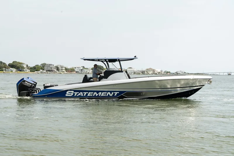 Slide: The Image of 2023 Statement 380 Open boat with triple engines on a trailer, surrounded by palm trees. - 3