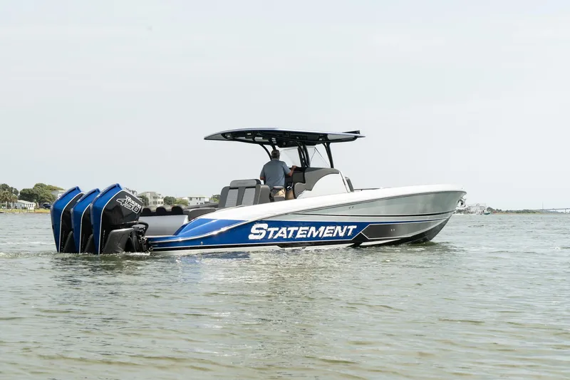 Slide: The Image of 2023 Statement 380 Open boat with triple 450R engines, parked near palm trees. - 4