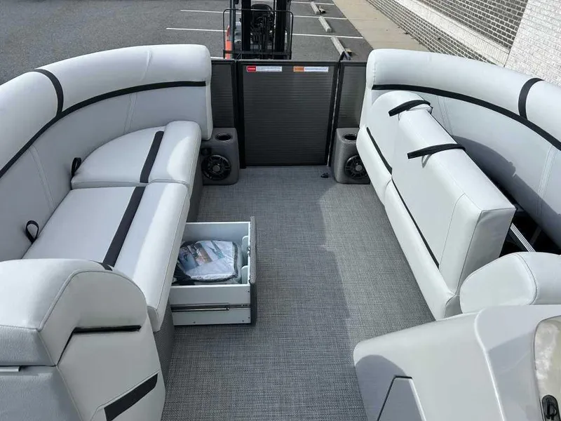 Slide: The Image of 2024 Crest Classic LX 220 SLC boat interior with gray seating and storage drawer. - 5