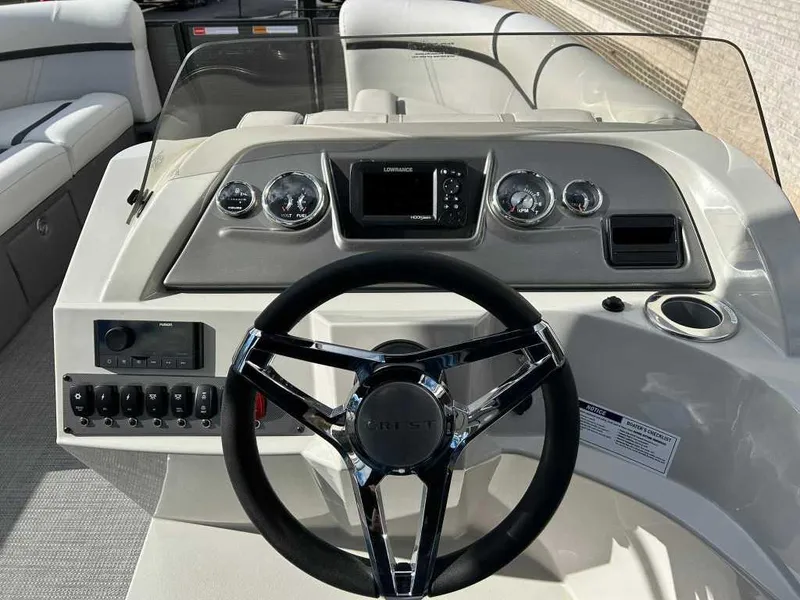 Slide: The Image of 2024 Crest Classic LX 220 SLC boat dashboard with steering wheel and controls. - 7