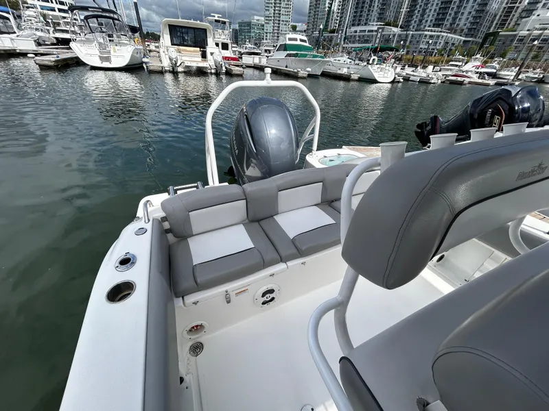 Slide: The Image of 2021 NauticStar 2102 Legacy boat at marina, featuring sleek seating and modern design. - 11