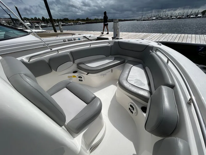 Slide: The Image of 2021 NauticStar 2102 Legacy boat interior with gray seating at marina. - 13