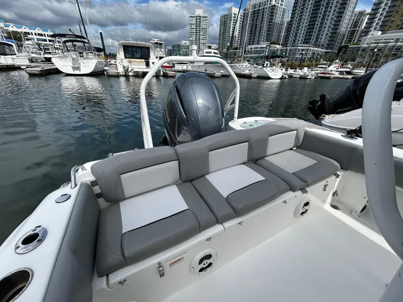 Slide: The Image of 2021 NauticStar 2102 Legacy boat docked in marina, featuring comfortable seating. - 6
