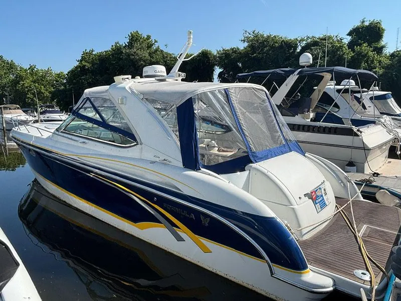 Slide: The Image of 2006 Formula 400 Super Sport boat docked at marina, featuring sleek design and blue accents. - 0