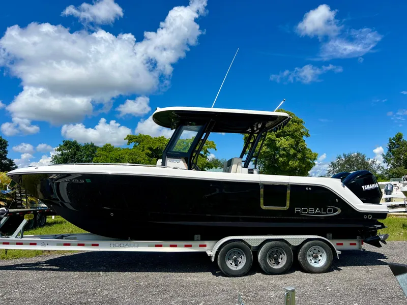 Slide: The Image of 2021 Robalo R272 Center Console boat on trailer under blue sky. - 0