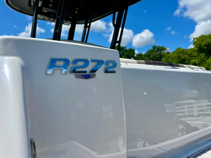 Slide: The Image of 2021 Robalo R272 Center Console boat with blue skies and trees in the background. - 10