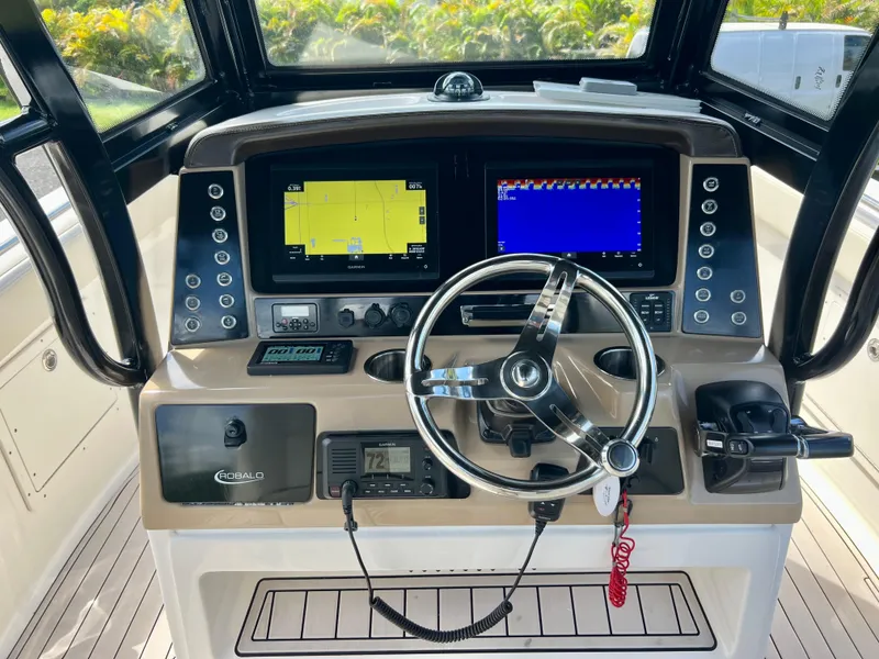 Slide: The Image of 2021 Robalo R272 Center Console helm with dual displays and steering wheel. - 14