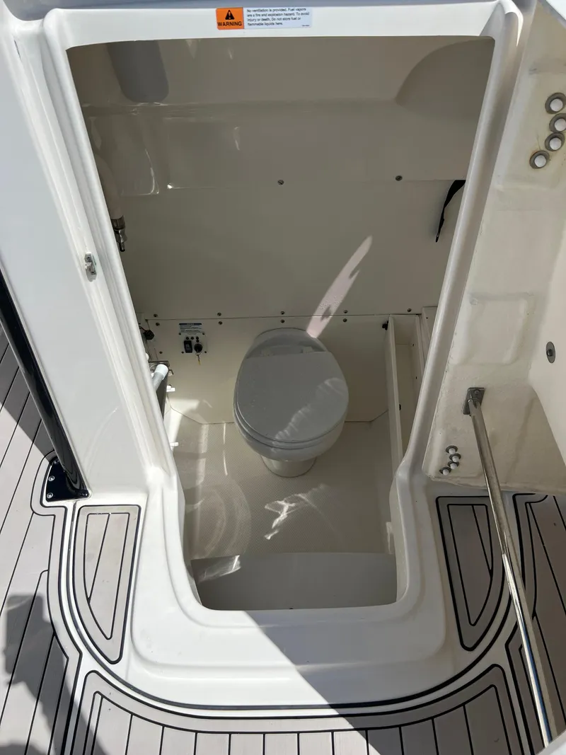 Slide: The Image of 2021 Robalo R272 Center Console boat interior with toilet. - 18