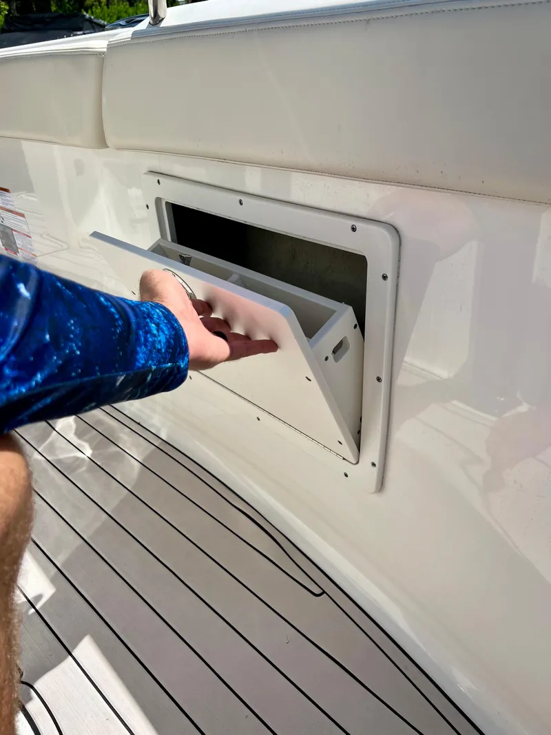 Slide: The Image of Person opening storage compartment on 2021 Robalo R272 Center Console boat. - 21