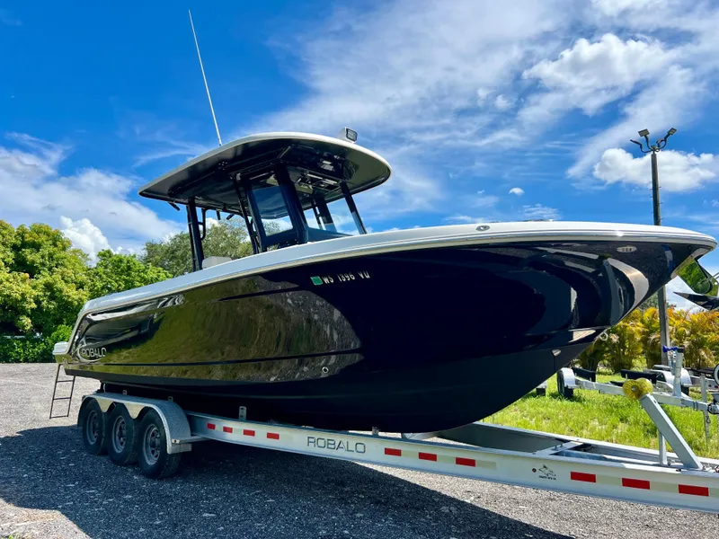 Slide: The Image of 2021 Robalo R272 Center Console boat on trailer under blue sky. - 3