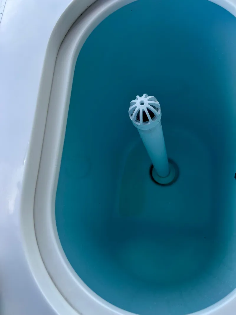 Slide: The Image of Robalo R272 Center Console 2021 livewell interior with blue water and central drain. - 30