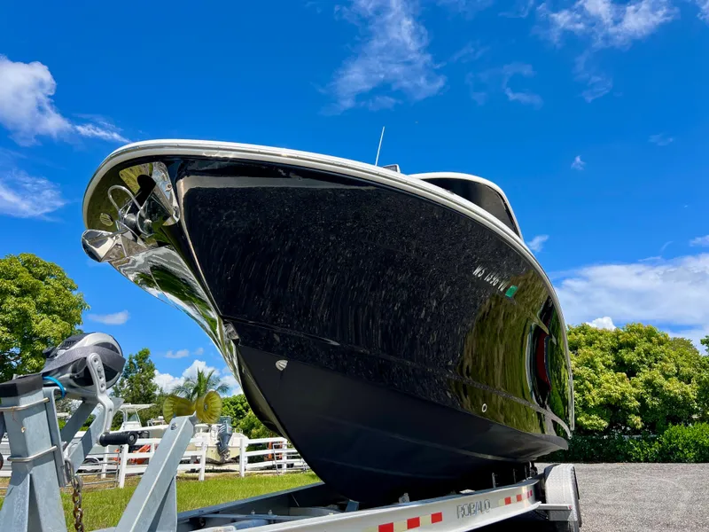 Slide: The Image of 2021 Robalo R272 Center Console boat on trailer under blue sky. - 4