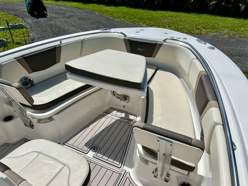 Slide: The Image of 2021 Robalo R272 Center Console boat interior with cushioned seating and table. - 8