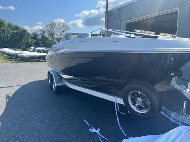 Slide: The Image of 2025 Tahoe T21 boat on trailer, parked outdoors near a building. - 4