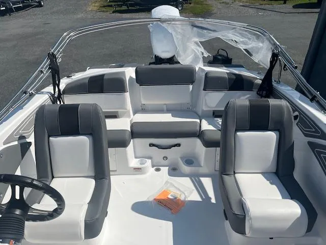 Slide: The Image of 2025 Tahoe T21 boat interior with gray and white seating, steering wheel, and open deck. - 5