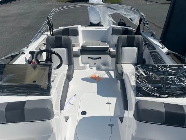 Slide: The Image of 2025 Tahoe T21 boat interior with gray seating and steering wheel, covered in protective plastic. - 6