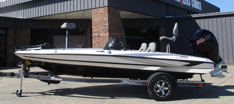 The Image of 2025 Triton 18 TrX boat on trailer, parked outside a building. - 1