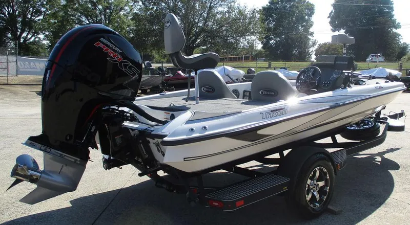 Slide: The Image of 2025 Triton 18 TrX boat with powerful outboard motor, parked on a trailer. - 3