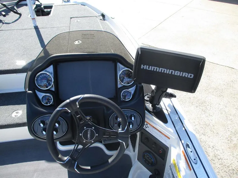 Slide: The Image of 2025 Triton 18 TrX boat dashboard with steering wheel and Humminbird fish finder. - 6