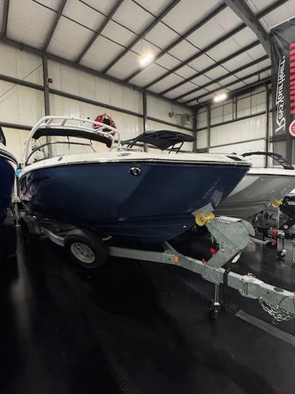 Slide: The Image of 2025 Yamaha Boats 252S in showroom, blue hull, on trailer. - 4