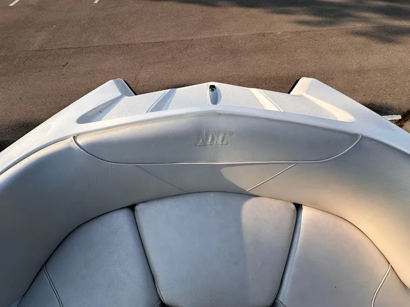 Slide: The Image of 2017 MasterCraft NXT22 boat interior with gray seating in a parking lot. - 13