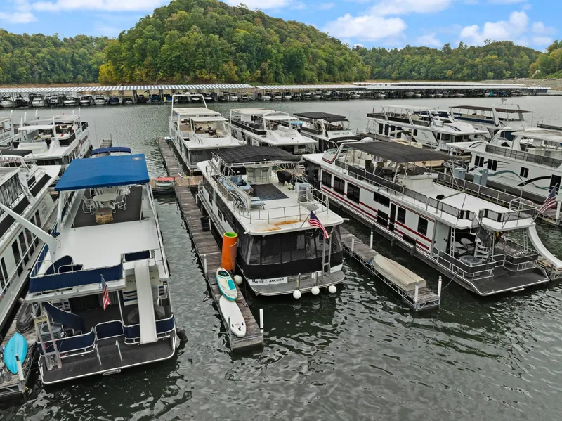 Slide: The Image of Houseboats docked at a marina, featuring a 2003 Monticello 18 X 70 River Yacht. - 10