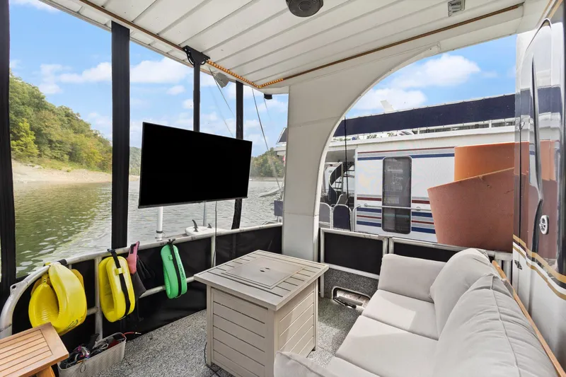 Slide: The Image of 2003 Monticello 18 X 70 River Yacht interior with sofa, TV, and scenic water view. - 14