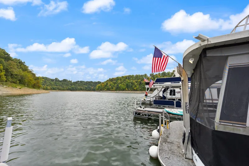 Slide: The Image of 2003 Monticello 18 X 70 River Yacht docked on a scenic lake with American flag. - 19