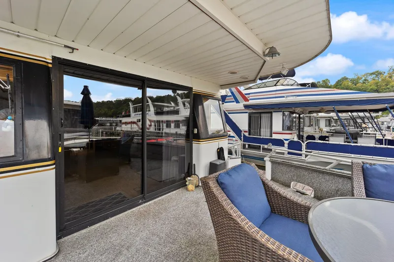 Slide: The Image of 2003 Monticello 18 X 70 River Yacht deck with wicker seating and marina view. - 30