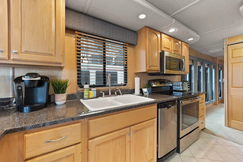 Slide: The Image of Modern kitchen interior in 2003 Monticello 18 X 70 River Yacht, featuring wood cabinets and stainless appliances. - 36