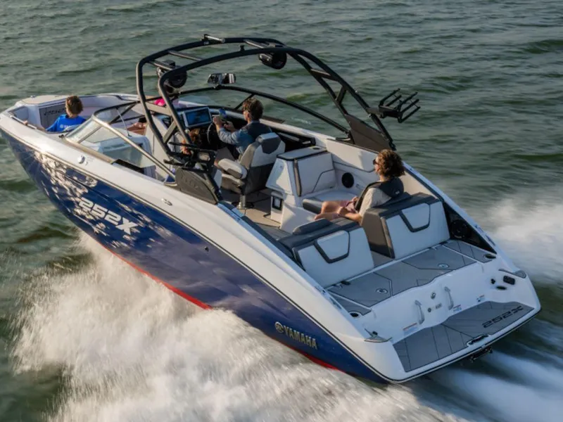 Slide: The Image of 2025 Yamaha Boats 252XE cruising on water with passengers enjoying the ride. - 4