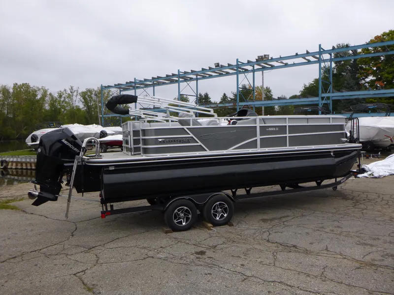 Slide: The Image of 2024 Ranger Reata 223C pontoon boat on trailer, parked outdoors. - 0