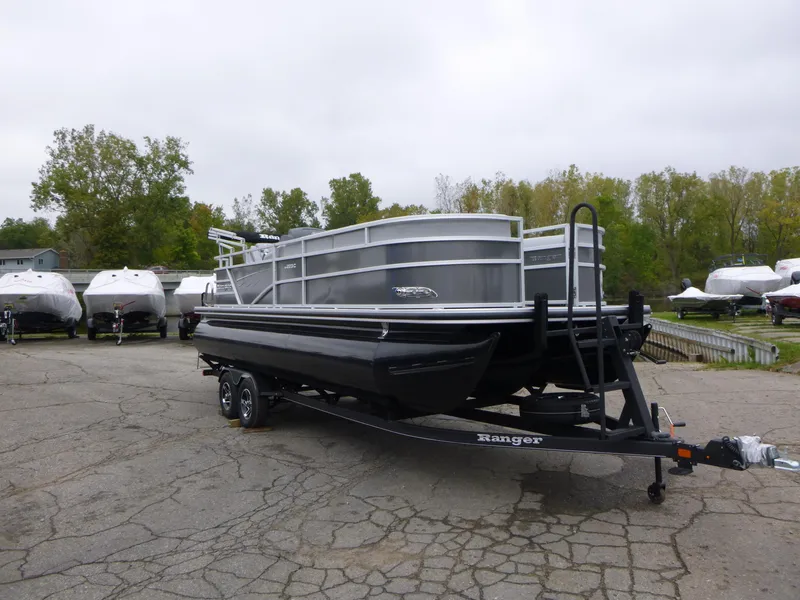 Slide: The Image of 2024 Ranger Reata 223C pontoon boat on trailer in parking lot. - 12